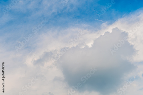 Layers of cirrocumulus and cirrus clouds in upper atmosphere in blue sky.