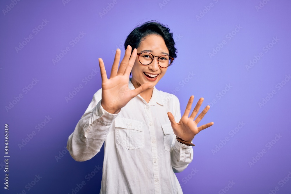 Young beautiful asian girl wearing casual shirt and glasses standing over purple background afraid and terrified with fear expression stop gesture with hands, shouting in shock. Panic concept. Young beautiful asian girl wearing casual shirt and glasses standing over purple background afraid and terrified with fear expression stop gesture with hands, shouting in shock. Panic concept.