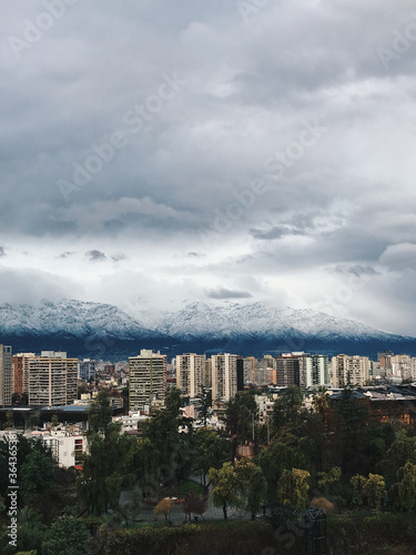 Beautiful and dramatic cloudy sky over Santiago downtown and snowed Los Andes mountains, Chile