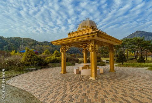Golden colored gazebo under cloudy sky located in a public park 15KM north of Daejeon, South Korea © aminkorea