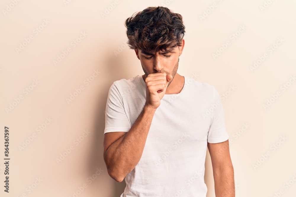 Young hispanic man wearing casual clothes feeling unwell and coughing as symptom for cold or bronchitis. health care concept.