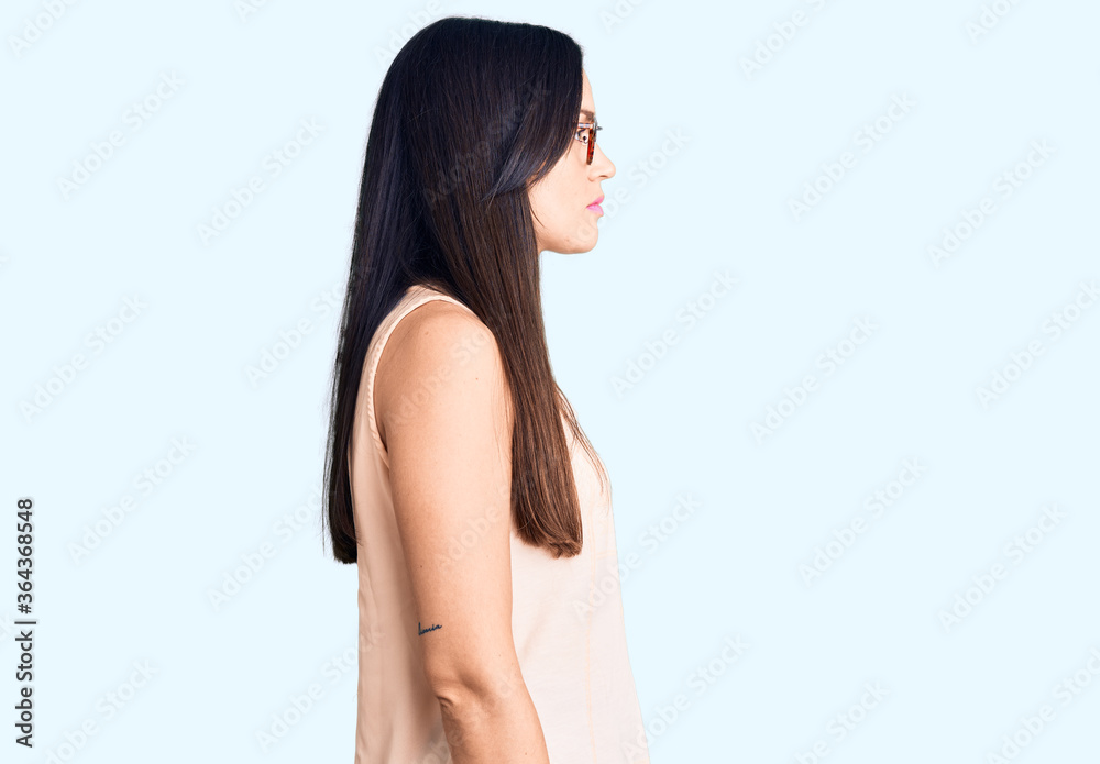 Young beautiful caucasian woman wearing casual clothes and glasses looking to side, relax profile pose with natural face with confident smile. Young beautiful caucasian woman wearing casual clothes and glasses looking to side, relax profile pose with natural face with confident smile.
