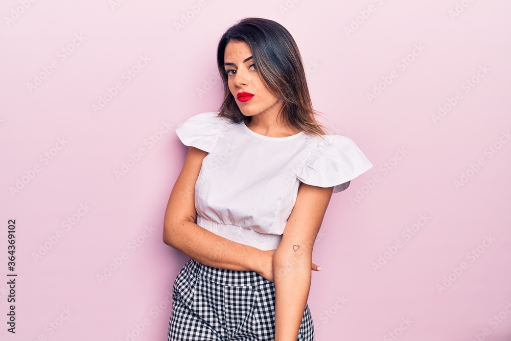 Young beautiful brunette woman wearing casual clothes standing over isolated pink background Young beautiful brunette woman wearing casual clothes standing over isolated pink background