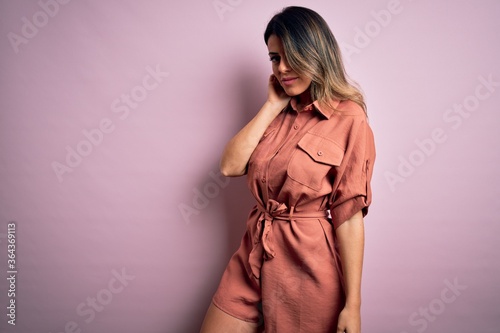 Young beautiful woman wearing fashion urban clothes, model wearing casual street style standing over pink background