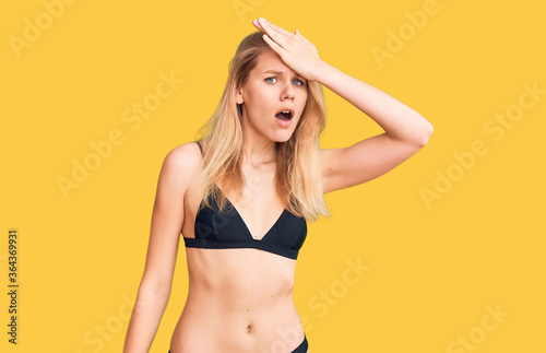 Young beautiful blonde woman wearing bikini surprised with hand on head for mistake, remember error. forgot, bad memory concept. © Krakenimages.com