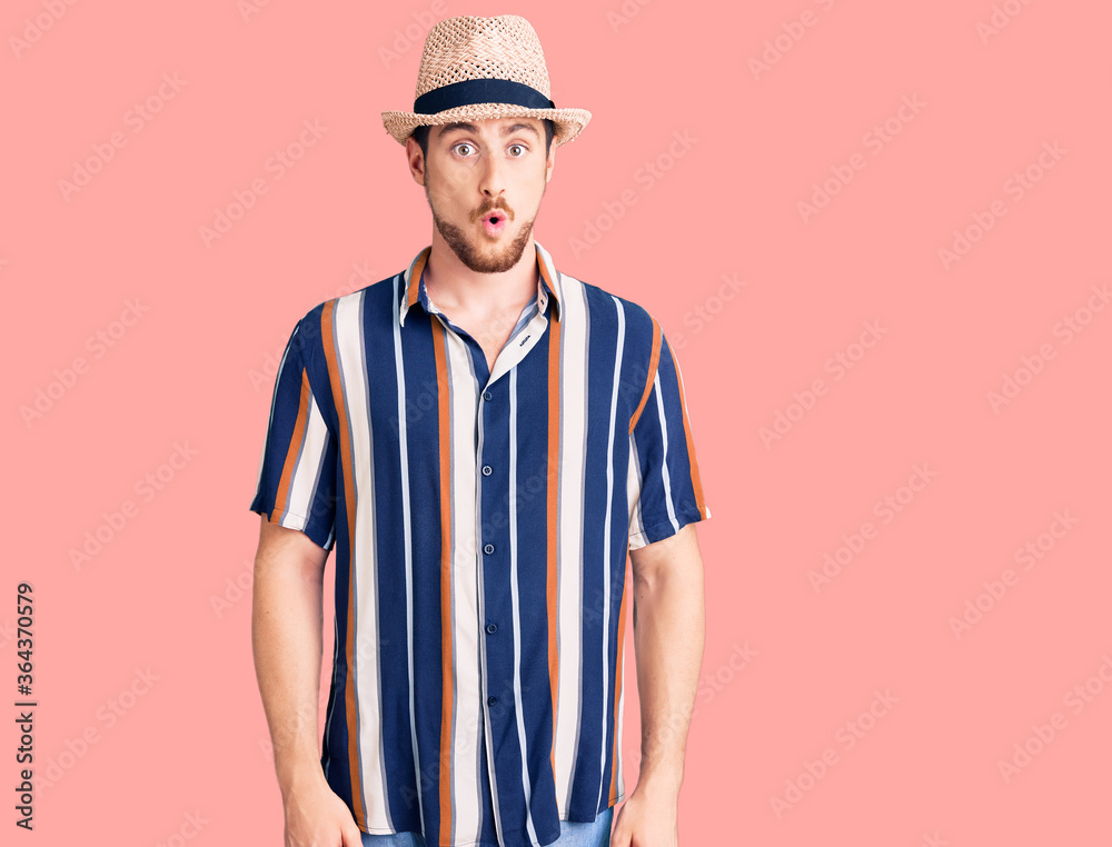 Young handsome caucasian man wearing summer hat afraid and shocked with surprise expression, fear and excited face. Young handsome caucasian man wearing summer hat afraid and shocked with surprise expression, fear and excited face.
