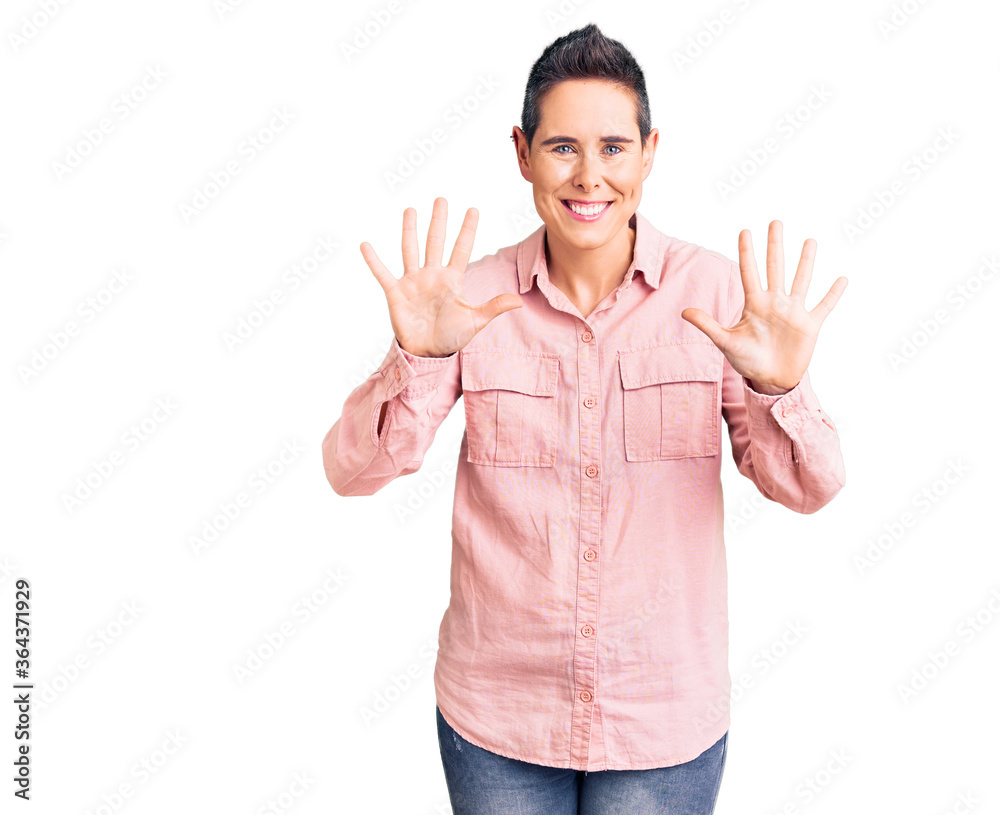 Young woman with short hair wearing casual clothes showing and pointing up with fingers number ten while smiling confident and happy. Young woman with short hair wearing casual clothes showing and pointing up with fingers number ten while smiling confident and happy.