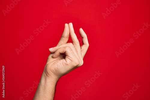 Hand of caucasian young man showing fingers over isolated red background snapping fingers for success  easy and click symbol gesture with hand