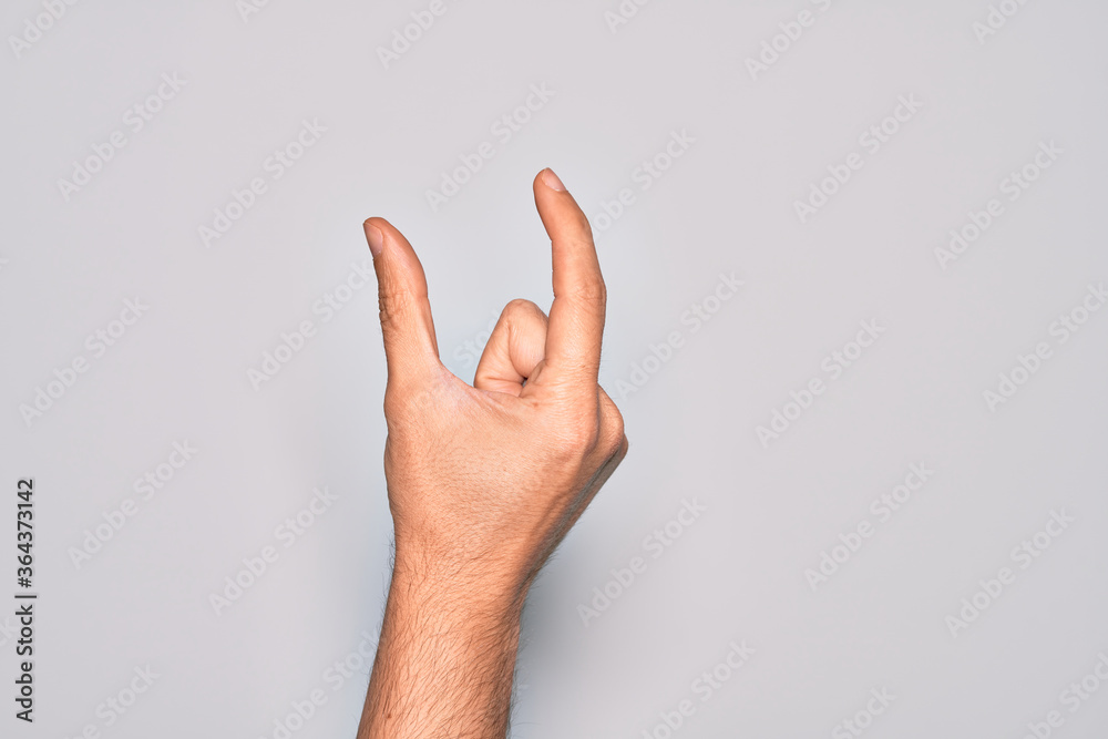 Hand of caucasian young man showing fingers over isolated white background picking and taking invisible thing, holding object with fingers showing space Hand of caucasian young man showing fingers over isolated white background picking and taking invisible thing, holding object with fingers showing space