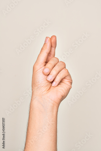 Hand of caucasian young man showing fingers over isolated white background holding blank space with thumb finger, business and advertising