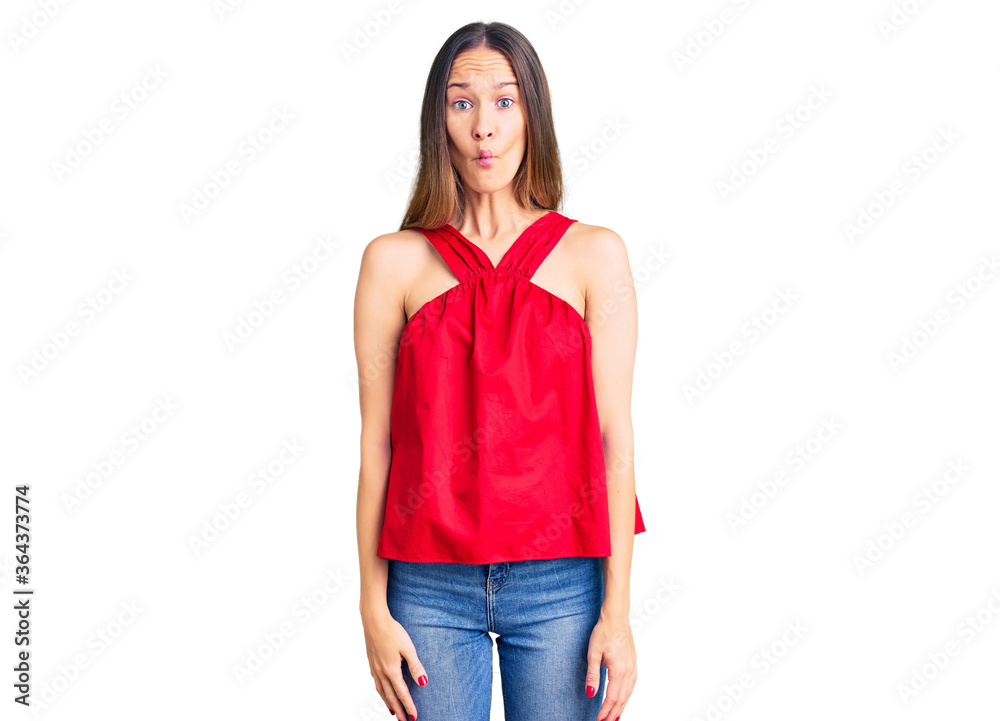 Beautiful brunette young woman wearing casual clothes making fish face with lips, crazy and comical gesture. funny expression. Beautiful brunette young woman wearing casual clothes making fish face with lips, crazy and comical gesture. funny expression.