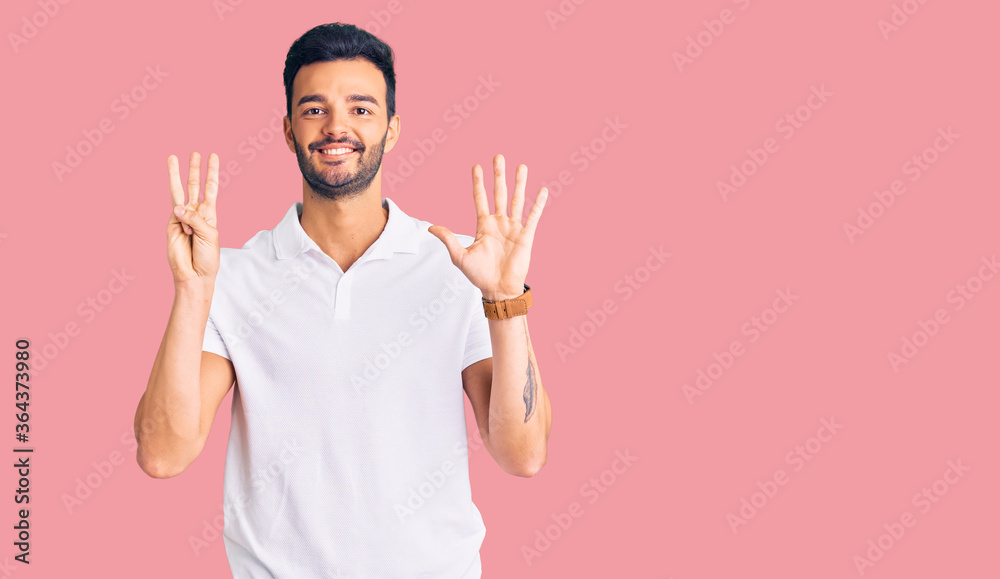 Young handsome hispanic man wearing casual clothes showing and pointing up with fingers number eight while smiling confident and happy. Young handsome hispanic man wearing casual clothes showing and pointing up with fingers number eight while smiling confident and happy.