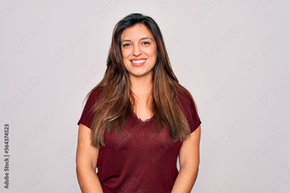 Young hispanic woman wearing casual t-shirt standing over isolated background with a happy and cool smile on face. Lucky person. Young hispanic woman wearing casual t-shirt standing over isolated background with a happy and cool smile on face. Lucky person.