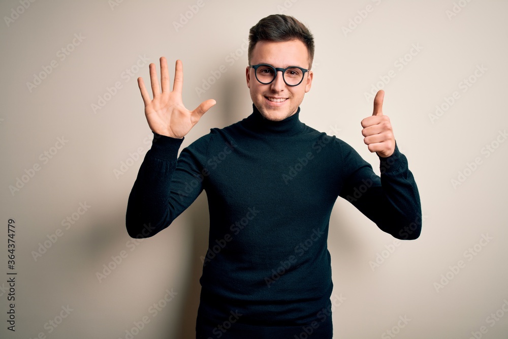 Fototapeta premium Young handsome caucasian man wearing glasses and casual sweater over isolated background showing and pointing up with fingers number six while smiling confident and happy.