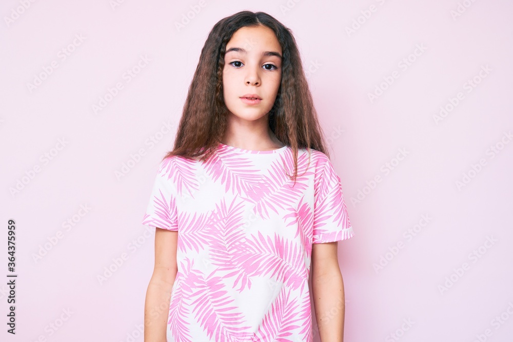 Cute hispanic child girl wearing casual clothes with serious expression on face. simple and natural looking at the camera.