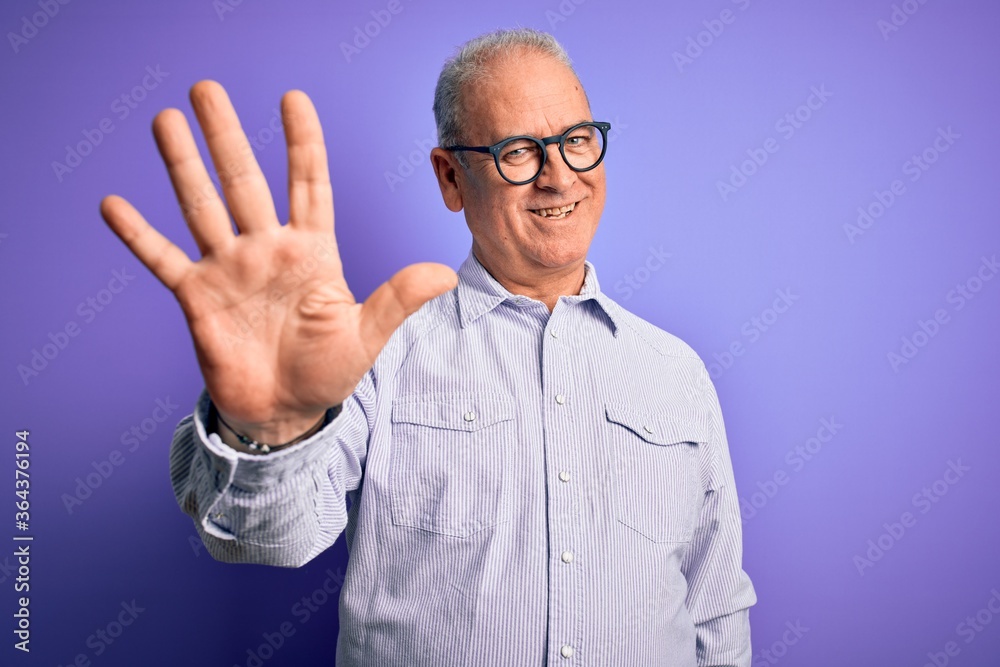 Middle age handsome hoary man wearing striped shirt and glasses over purple background showing and pointing up with fingers number five while smiling confident and happy.