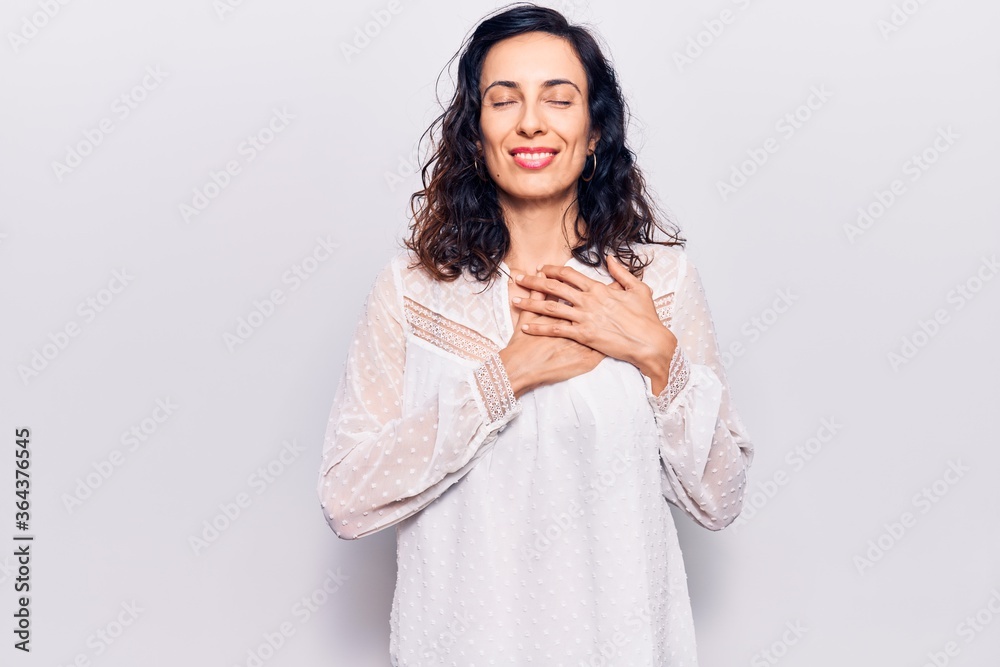 Young beautiful hispanic woman wearing casual clothes smiling with hands on chest with closed eyes and grateful gesture on face. health concept. Young beautiful hispanic woman wearing casual clothes smiling with hands on chest with closed eyes and grateful gesture on face. health concept.