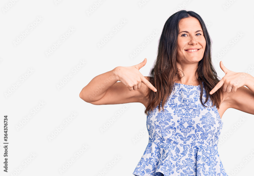 Young beautiful brunette woman wearing casual t-shirt looking confident with smile on face, pointing oneself with fingers proud and happy.