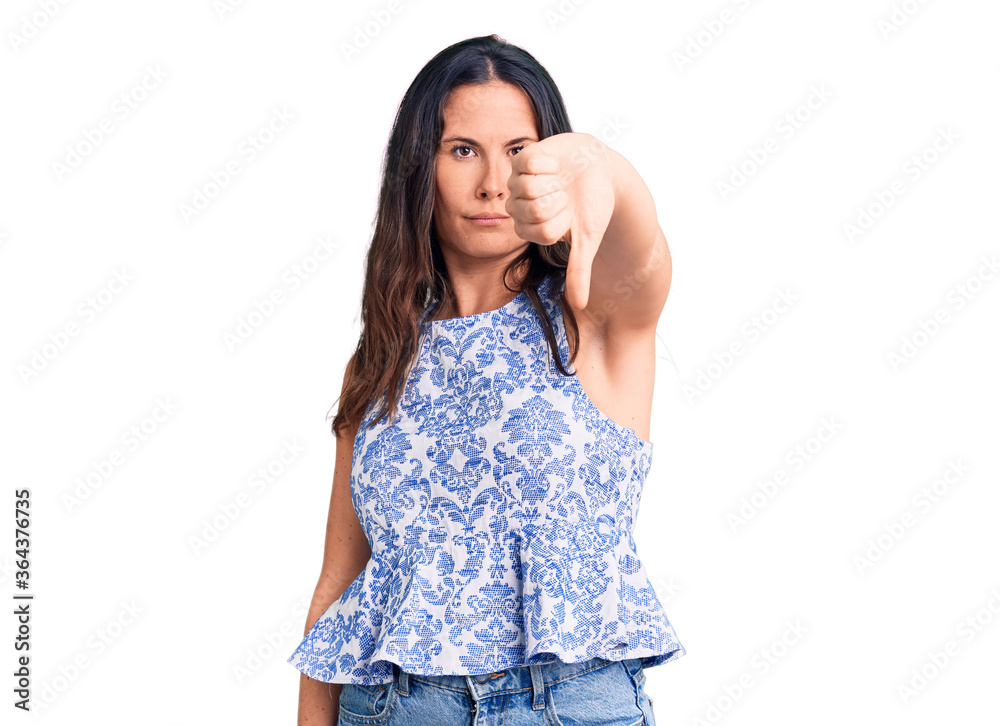 Young beautiful brunette woman wearing casual t-shirt looking unhappy and angry showing rejection and negative with thumbs down gesture. bad expression. Young beautiful brunette woman wearing casual t-shirt looking unhappy and angry showing rejection and negative with thumbs down gesture. bad expression.