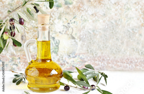 olive oil in a bottle and a sprig of fresh olives. copy space