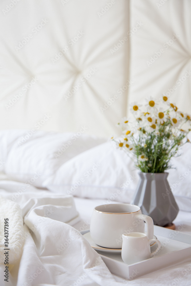 Cozy breakfast in bed, cup of coffee and milk on the grey fabric, space for text. Alarm clock for seven in the morning. Cozy breakfast in bed, cup of coffee and milk on the grey fabric, space for text. Alarm clock for seven in the morning.