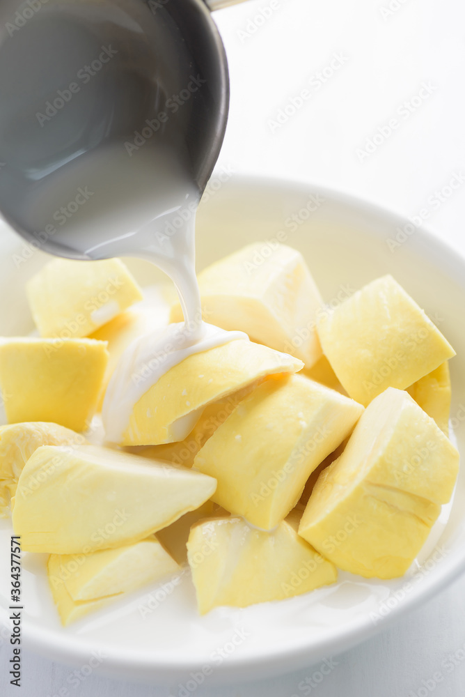 Thai dessert, sliced durian fruit in a bowl eating with coconut milk Thai dessert, sliced durian fruit in a bowl eating with coconut milk