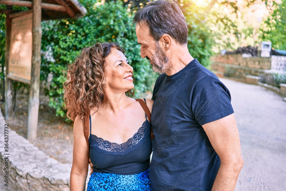 Middle age couple wearing casual clothes smiling happy at the forest Middle age couple wearing casual clothes smiling happy at the forest