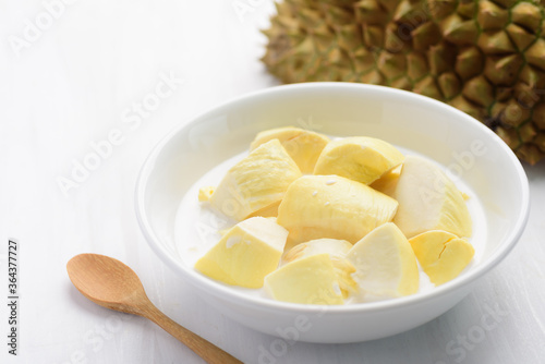 Thai dessert, sliced durian fruit with coconut milk in a bowl on white table background
