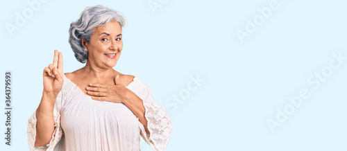 Konstfotografi Senior woman with gray hair wearing bohemian style smiling swearing with hand on