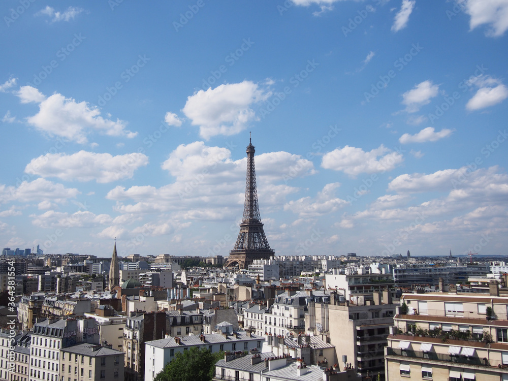 Paris skyline with an impressive Eiffel Tower in the pleasant blue sky.