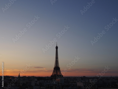 Paris skyline with an impressive Eiffel Tower in the pleasant sunset sky.