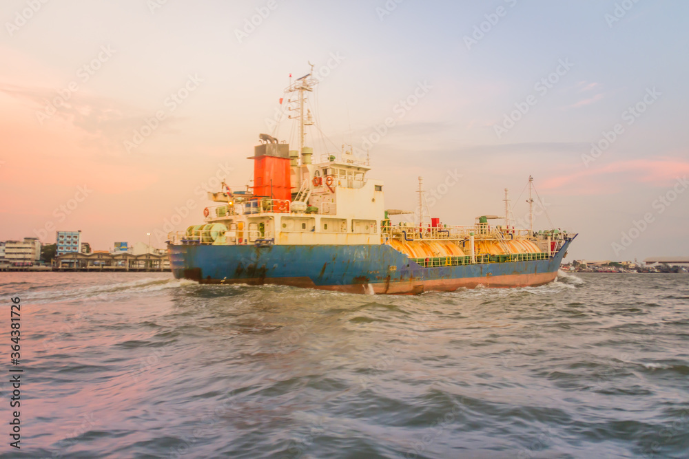 Fototapeta premium Massive container ship for import export and business logistic. Big cargo ship is leaving from Bangkok Port Authority of Thailand or Klong Toey port along Chao Phraya river in Bangkok,Thailand.