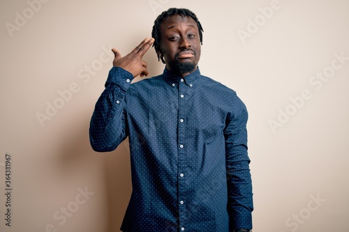 Young handsome african american man wearing casual shirt standing over white background Shooting and killing oneself pointing hand and fingers to head like gun, suicide gesture.