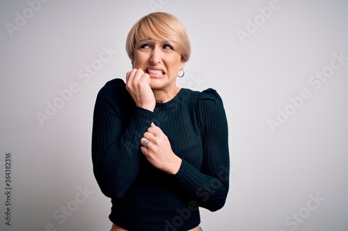 Tableau sur toile Young beautiful blonde woman with modern short hair hairstyle standing over isolated background looking stressed and nervous with hands on mouth biting nails