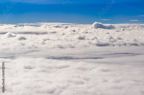 Beautiful cloudscape and blue sky from aerial view, nature view from above the sky and clouds. White clouds and blue sky view like the heaven from airplane window. Sunlight in the sky shines on clouds