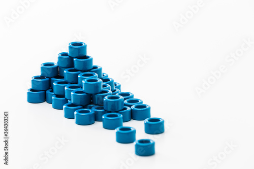 Closeup of Stack of Ferrite Magnetic Cores of Blue Color Placed in Batch. Isolated On White.