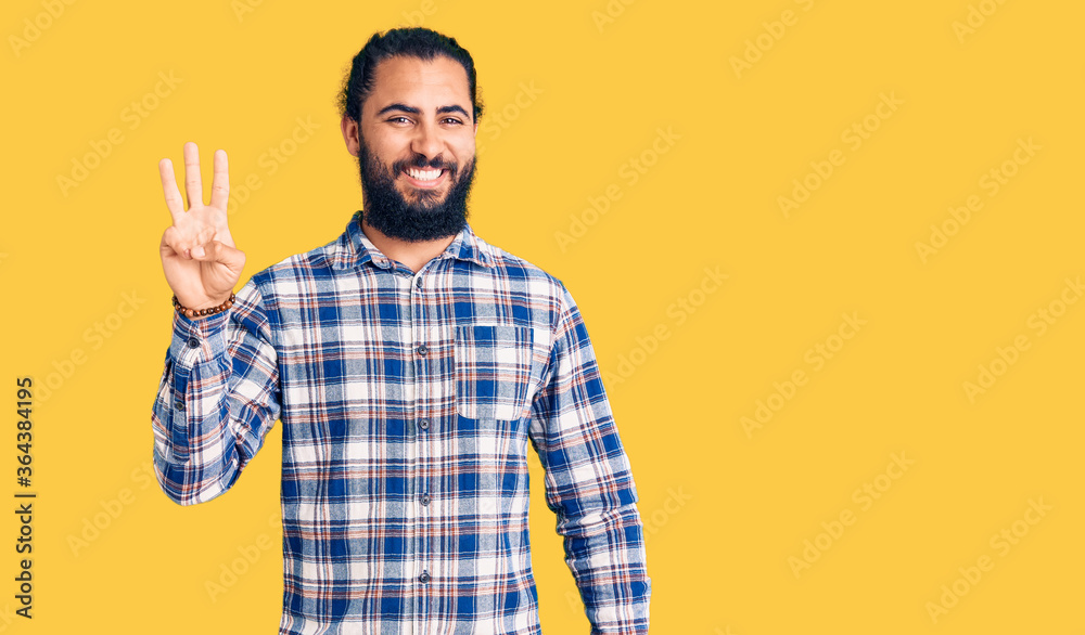 Young arab man wearing casual clothes showing and pointing up with fingers number three while smiling confident and happy. Young arab man wearing casual clothes showing and pointing up with fingers number three while smiling confident and happy.