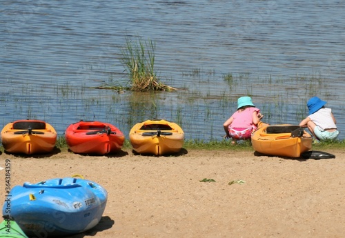 girls playing on beach, canoes