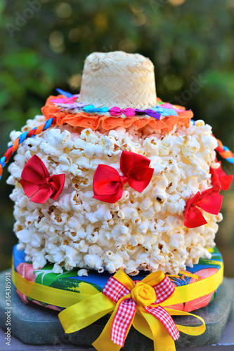 Bolo de pipoca decorado com chapéu de palha com laços coloridos 