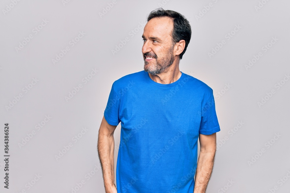 Middle age handsome man wearing casual t-shirt standing over isolated white background looking to side, relax profile pose with natural face and confident smile. Middle age handsome man wearing casual t-shirt standing over isolated white background looking to side, relax profile pose with natural face and confident smile.