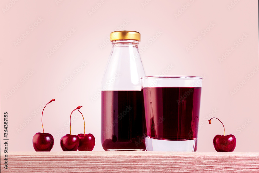 Natural cherry juice in glass and bottle with with sweet cherries on the wooden table. Natural cherry juice in glass and bottle with with sweet cherries on the wooden table.