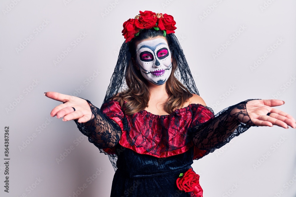Young woman wearing day of the dead costume over white looking at the camera smiling with open arms for hug. cheerful expression embracing happiness.