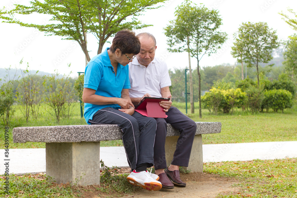 Elderly Chinese couple looking at the mobile tablet Elderly Chinese couple looking at the mobile tablet