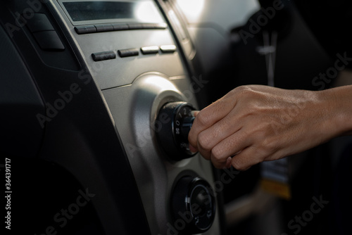 Young Woman Turning on car air conditioning system, © PK Studio