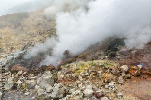 Breathtaking view of volcanic landscape, aggressive hot spring, eruption fumarole, gas-steam activity in crater of active volcano. Dramatic mountain landscape, travel destinations for active vacation.
