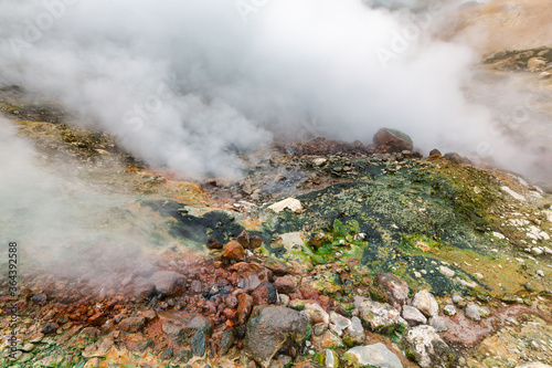 Mysterious view of volcanic landscape, aggressive hot spring, eruption fumarole, gas-steam activity in crater of active volcano. Picturesque mount landscape, travel destinations for vacation, hiking.