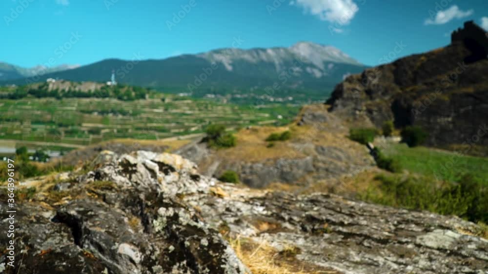 Beautiful vista overlooking Swiss Alps village of Sion with rocks in foreground