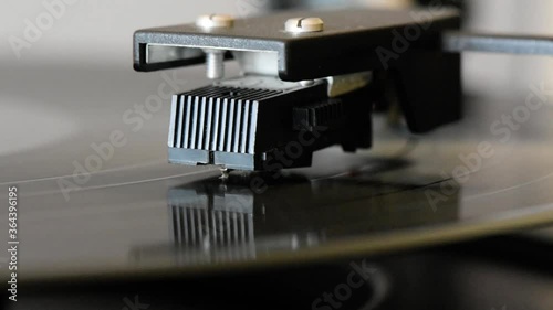 Close up of turntable needle on vinyl disc spinning. photo