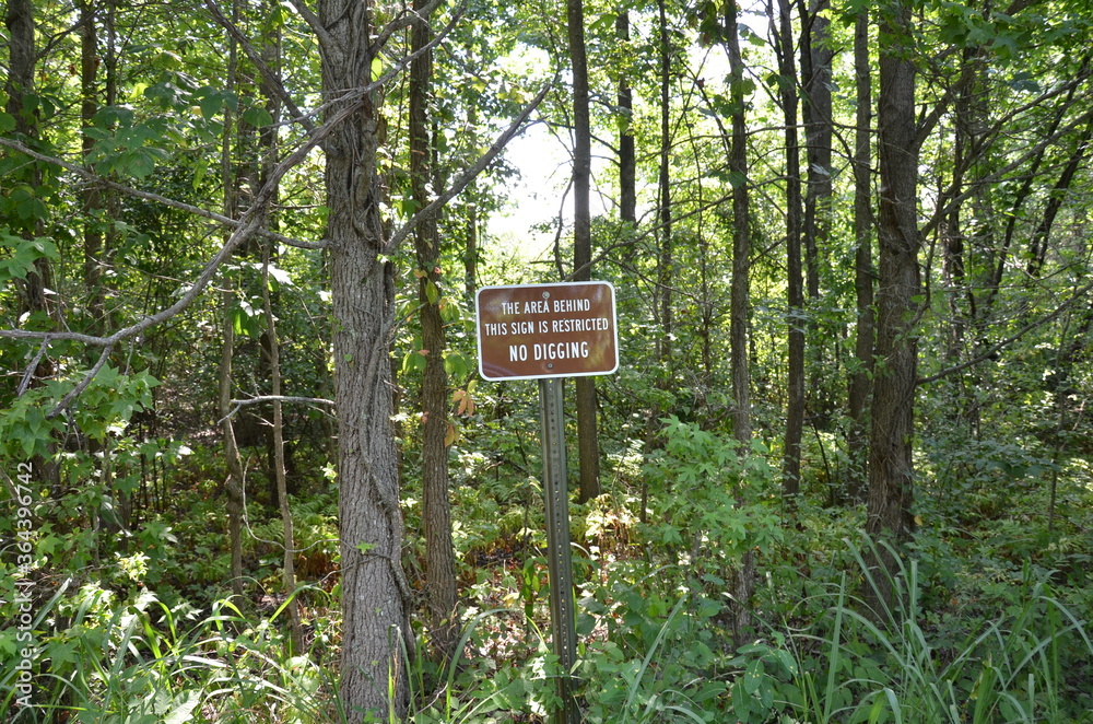 the area behind this sign is restricted no digging sign with trees