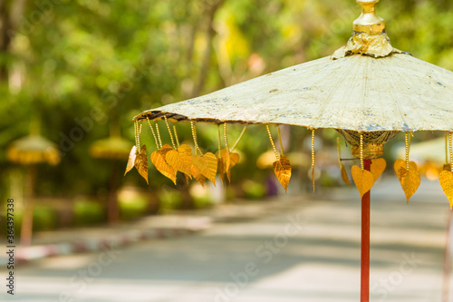An umbrella that is decorated with golden leaves.